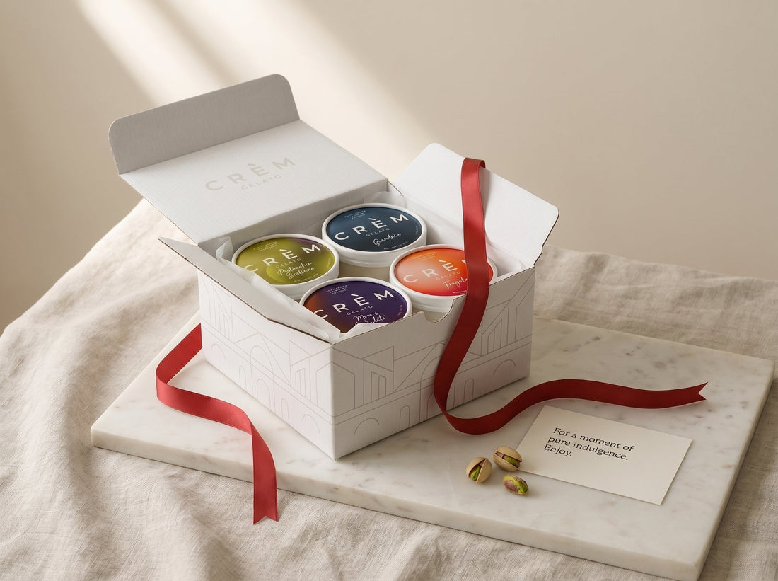 An open Crèm Gelato four-tub gift set with a red satin ribbon and a gift note